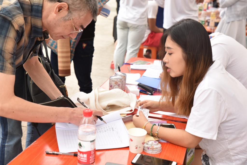 新生报到现场，工作人员正在为家长答疑